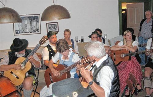 Abwechselnd zu spielen und zuzuhören gilt es für die Musikanten beim Hoagart – im Vordergrund das „Seeoner Gitarrentrio“ in Aktion, im Hintergrund die „Alzberg-Musi“ und eine der Sängerinnen vom „Kirchseeoner Zwoagsang“.Foto iigr