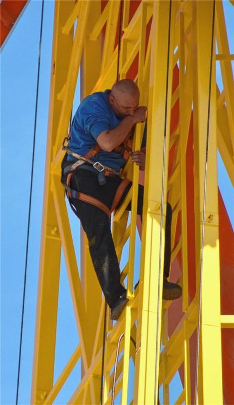 Akrobat beim Riesenrad-Aufbau