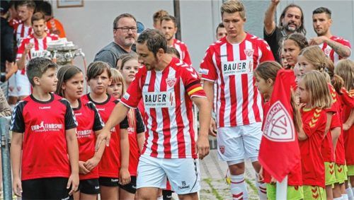 Auf geht’s zum dritten Heimspiel der Buchbacher: Kapitän Markus Grübl schnappt sich eins der Einlaufkinder.Foto Buchholz