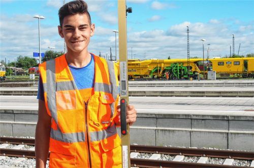 Das Gleisspurüberhöhungsmessgerät in der Hand von Devrim Sieren spielt für die Instandhaltung von Gleisen eine wichtige Rolle – genau wie die gelbe Weichenstopfmaschine im Hintergrund. Foto  kob