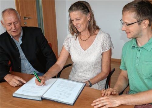 Vertragsabschluss: Marianne Steindlmüller unterzeichnet im Beisein von Philipp Ramming (links) und David Schmidtner den Vertrag zur Nutzung des Rathausdachs als Standort für eine Fotovoltaikanlage.Foto Rehberg