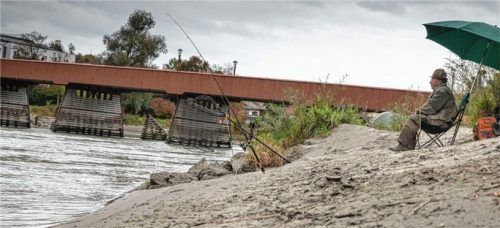 In der Ruhe liegt die Kraft: Ein Fischer vor der roten Brücke wartet, dass ein Fisch anbeißt.Foto john cater