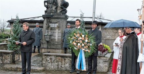 Bürgermeister Georg Weigl bei seiner Ansprache am Kriegerdenkmal mit Johann Stürzer sowie Zweitem Bürgermeister Heinz Speiser mit dem Kranz. Foto  Stache