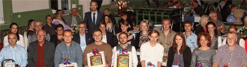 Florian Bauer, Geschäftsführer der Bauer Gruppe (stehend) inmitten der Jubilare. Foto re