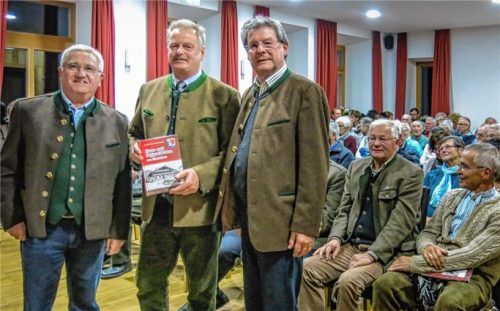 Gegen das Vergessen angeschrieben haben Stefan Entfellner (links) und Bernhard Greimel (rechts) mit ihren 527 Seiten „Haus- und Hofgeschichten von Oberwössen“. Bei der Vorstellung des Buches über die Oberwössner Ortsgeschichte war der Saal im Schulhaus voll. Auch Bürgermeister Ludwig Entfellner (Mitte) freut sich über das Buch.Foto  lfl