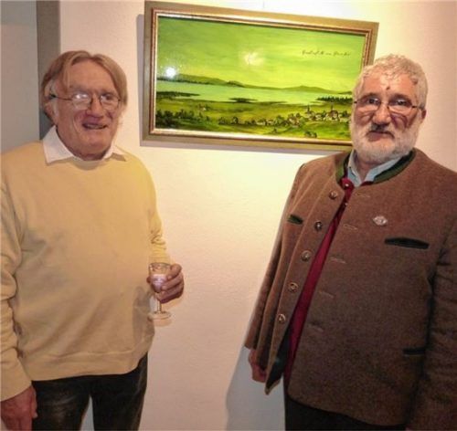 Kurt Lohwasser aus Grabenstätt (links) stellt derzeit seine sehenswerten Hinterglasbilder in der Grabenstätter Schlossökonomie aus. Bürgermeister Georg Schützinger freute sich besonders über das Grabenstätt-Gemälde (im Hintergrund), das die Gemeinde von Lohwasser geschenkt bekam. Als Vorlage diente ihm eine Skizze aus dem Jahr 1860. Foto  Müller
