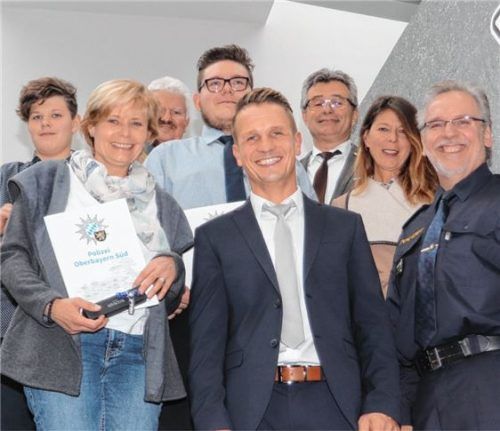 Polizeipräsident Robert Kopp (erste Reihe rechts), Bürgermeister Erwin Baumgartner (dritte Reihe links), Kripo-Leiter Christian Schuster (dritte Reihe rechts) und Sachbearbeiter Martin Schindler (erste Reihe Mitte) bedanken sich bei den beiden Lebensrettern Frau Werner (erste Reihe links) und Herrn Küppers (zweite Reihe Mitte).Foto re