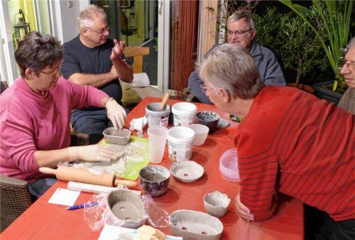 Rosl Grupp (links) bringt den Knetbeton in eine Form. Die anderen Teilnehmer sehen gespannt zu.Foto Hoffmann