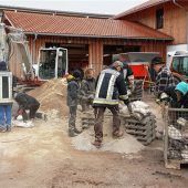 Helfer befüllen 2000 Säcke mit Sand