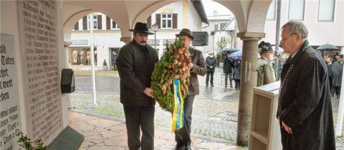 Zum Gedenken an die Gefallenen der vergangenen Kriege legten im Beisein von Zweitem Bürgermeister Hans-Jürgen Schuster (rechts) Martin Kollmannsberger (Mitte) und Peter Fischer (links) im Namen des Marktgemeinderats sowie Hans Berger und Andreas Friedrich für die Vereine Kränze am Kriegerdenkmal an der Taufkapelle nieder. Foto Berger