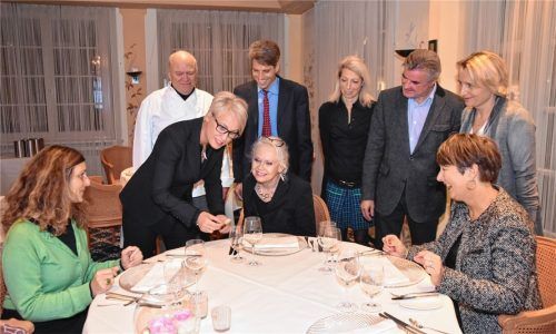 Christine Kesmarki (stehend, schwarzer Hosenanzug) erklärte Lehrern der Berufsschule II in Rosenheim, wie das Besteck auf einem Esstisch korrekt platziert wird. Sternekoch Heinz Winkler von der Residenz in Aschau (hinten links) schaut interessiert zu. Erika Körner-Metz, Initiatorin des Programms an der Schule (rechts neben Kesmarki) verfolgte die Ausführungen ebenfalls aufmerksam. Foto Schlecker