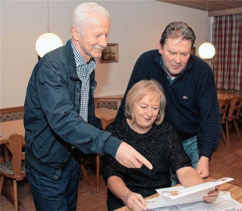 Das passt: Sozialreferent Dieter Bräunlich (links) und Stadtrat Rudi Gebhart werfen zusammen mit Weihnachtsstuben-Initiatorin Astrid Kotter einen Blick auf die Plakate, mit denen die Veranstaltung beworben wird.