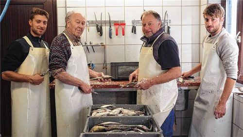 Drei Fischergenerationen beim Verarbeiten ihres Fangs (von links): Florian Lex, Holmer Lex, Thomas Lex und Tassilo Lex. Florian und Tassilo sind Zwillingsbrüder, Thomas ist der Vater, Holmer Lex der Großvater. Foto Ulli Seer