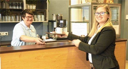 Heide Z. (links) reicht Hausleiterin Hanna Zenker einen Kaffee. Beide arbeiten gerne zusammen.