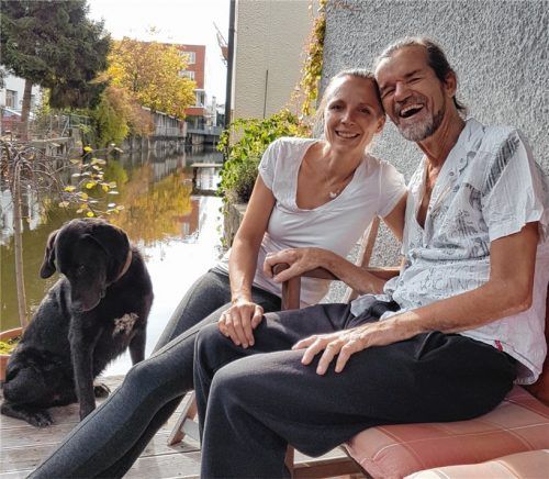 Nico Kornhass mit seiner Frau Steffi, Hund Ruma und einem von Herzen kommenden Lachen an seinem ganz persönlichen Kraftplatz, dem Steg direkt am Wasser. Auch im Winter genießt er es – eingehüllt in einen dicken Schlafsack – dort zu sein.Foto privat