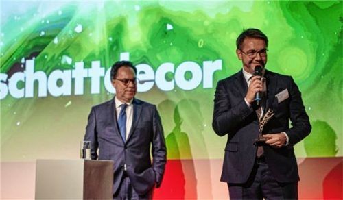 Roland Auer, Vorstandsvorsitzender der Schattdecor AG (rechts), mit dem Preis, den er von Holger Lösch, Bundesverband der deutschen Industrie (BDI), überreicht bekam. Foto re