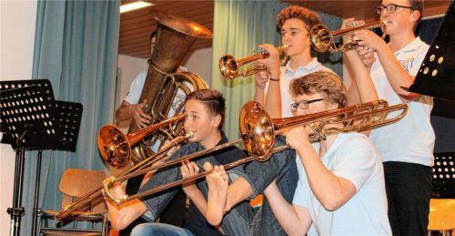 Viel Zehenspitzengefühl: Sehr mutig traten diese Musiker auf, denn die beiden Posaunisten spielten ihre Musikgeräte barfuß mit den Zehen und erhielten dafür sehr viel Beifall. Auf dem Bild vorne von links: Thomas Meindl und Daniel Müller (beide Posaune), dazwischen, versteckt auf dem Stuhl sitzend und mit den Zehen beide Posaunen spielend, Peter Nußreiner, Paul Stettner (an der Tuba), hintere Reihe von links: Michael Hanslmaier und Jakob Gritto (beide Trompete). Sie spielten von der österreichischen Brassband Mnozil „Lonely Boy“.Foto tf