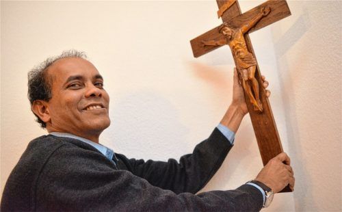 „Wenn ich den Menschen ein kleines Stück meines Glaubens geben kann, macht mich das froh“, sagt Pater John Kuttikottayil, der in seiner Wohnung in St. Peter und Paul unbedingt noch das Kreuz an die Wand hängen muss. Foto ha