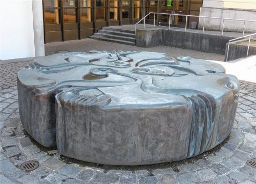 Der Bildhauer Alfred Regnat gewann 1983 den Wettbewerb für den Brunnen im neu zu gestaltenden Pausenhof des Ignaz-Günther-Gymnasiums. Die Bronzeskulptur setzt das Motiv des sprudelnden Quellsteines in einer abstrahierten Formum.Foto Frick