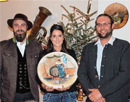 Gratulation an die Siegerin: Schützenmeister Andreas Müller und sein Stellvertreter Peter Fischer junior überreichen die Ehrenscheibe an Dorfkönigin Lisa Fuchs. Foto re