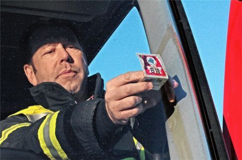 Eine Handlung, mit der er sich nicht anfreunden will: Kreisbrandmeister Joachim Buchmann bringt an der Windschutzscheibe eines Einsatzfahrzeugs der Feuerwehr Kiefersfelden eine Vignette an.Foto  Reisner