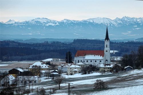 Eiskaltes Kirchdorf „kuschelt“ sich an die Alpen