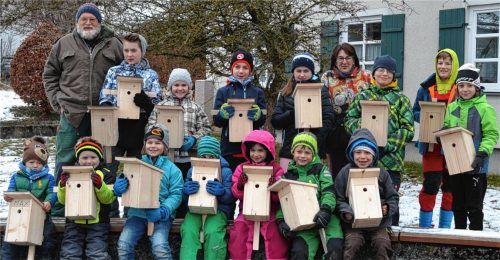 Aufgereiht wie die Vöglein auf der Stange: Stolz präsentieren die Kinder ihre Nistkästen, die sie unter Anleitung von Gartenbauvereinsvorstand Thomas Pummerer (links) selbst gebaut hatten. Foto Niessen