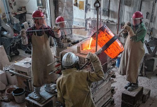 Dampfend und zischend fließt die rot glühende, 1000 Grad heiße Bronzelegierung in die Schamottform.Fotos re