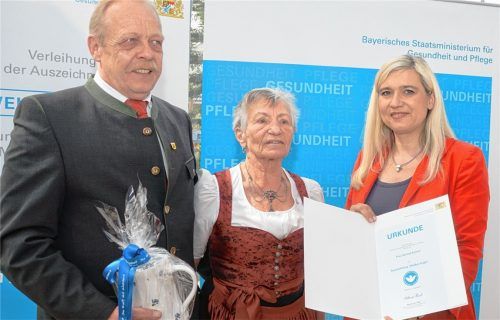 Bayerns Gesundheits- und Pflegeministerin Melanie Huml (rechts) überreicht die Auszeichnung „Weißer Engel“ an Gertrud Scheck aus Bad Endorf (Mitte) im Beisein von Wolfgang Kirner, Zweitem Bürgermeister Bad Endorfs. Foto StMGP
