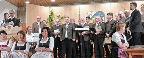 30 Jahre Ehrenamt beim Männergesangverein – Chorleiter Anton Fellner (links neben Notenständer) und Vorstand Sepp Kaffl (am Rednerpult).Foto  RE