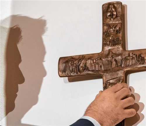 Der Schatten von Markus Söder ist zu sehen, als dieser ein Kreuz in der bayerischen Staatskanzlei aufhängt. Foto dpa