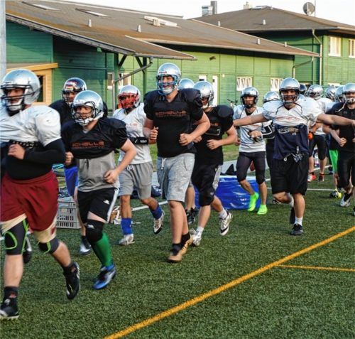 Helme und Schulterpolster: die Footballer der Rosenheimer Rebels beim Aufwärmen. Fotos Schirburr