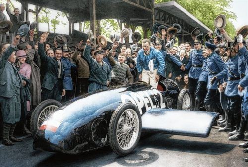 Hut ab vor dieser Leistung: Fritz von Opel wird nach seinem wilden Ritt im RAK 2 gefeiert. Das ursprüngliche Schwarzweiß-Pressefoto von 1928 hat Opel anlässlich des 90. Jubiläums der Rekordfahrt auf Basis historischer Fakten aufwendig koloriert. Foto opel