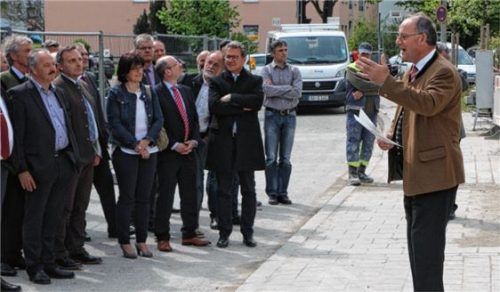 Landrat Berthaler zeigt Gästen beim Richtfest den Rohbau.