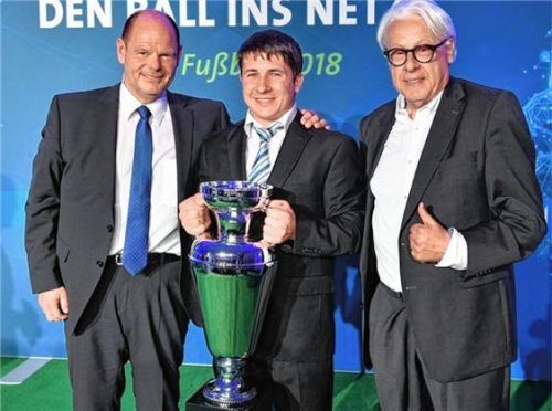 Markus Spötzl bekommt auf der Bühne den Siegerpokal von BFV-Schatzmeister Jürgen Faltenbacher (links) und BR-Sportchef Klaus Kastan überreicht.Foto BFV