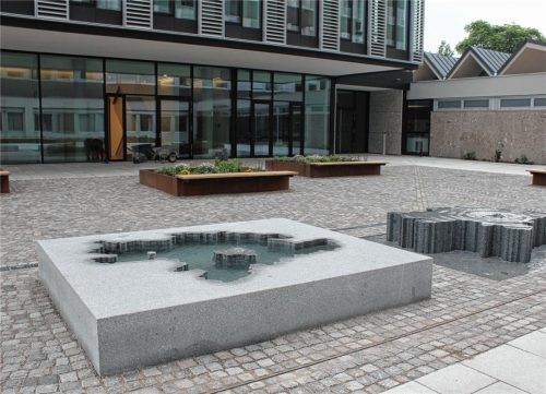 Wie ein großes Puzzle aus Granit wirkt die neue, zweiteilige Brunnenskulptur des Kiefersfeldener Bildhauers Toni Stegmayer auf der Platzanlage zwischen dem Alt- und dem Neubau des Landratsamtes Rosenheim. Die Umrisse der Stadt und des Landkreises Rosenheim werden hier auf witzige Weise umgesetzt.Foto Frick