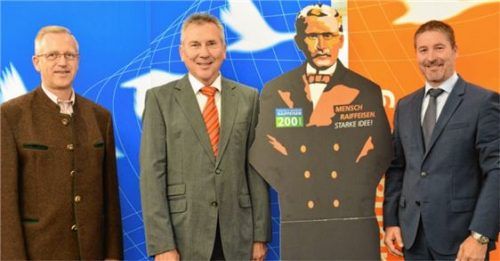 Aufsichtsratsvorsitzender Heinz Scheck, Vorstandsvorsitzender Albert Schweinsteiger und Vorstand Christian Trattner mit einer Figur von Genossenschaftspionier Friedrich Wilhelm Raiffeisen (von links). Foto re