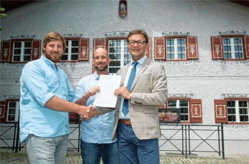 Der Mietvertrag ist unterschrieben. Bürgermeister Jürgen Seifert bezeichnete die Brüder Christoph (links) und Luitpold Müller als ideale Pächter für die Gastronomie im Erdgeschoss des Kronasthauses. Der Vertrag gilt ab Juli, dann soll zügig umgebaut und ein paar Wochen später eröffnet werden. Das denkmalgeschützte, über 400 Jahre alte Gebäude mit den markanten Fensterläden (im Hintergrund) auf dem Marktplatz gehört der Gemeinde seit 2017. Foto Berger