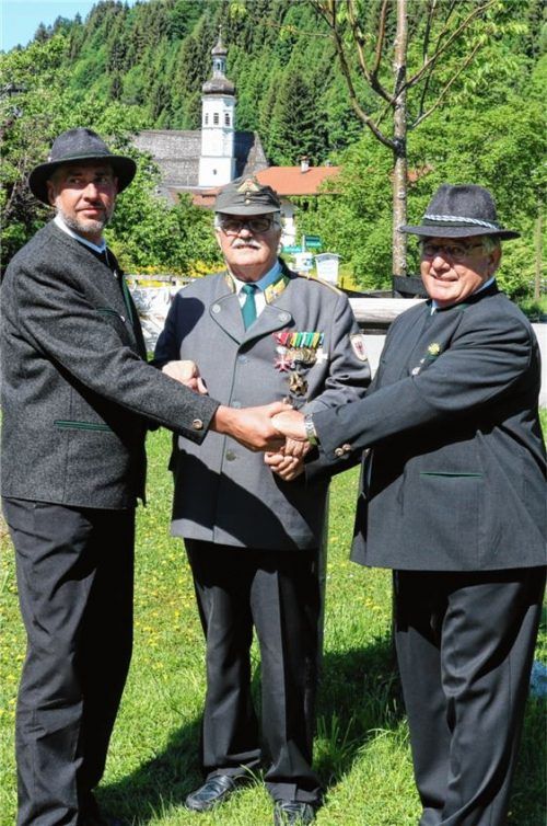 Die beiden Vorsitzenden der Krieger- und Soldatenkameradschaft Sachrang, Herbert Hoyer (rechts) und Erich Hofferer (links), mit dem Ehrenpräsidenten der Tiroler Kameradschaftsbünde, Hermann Hotter, an der Sachranger Friedenslinde. Foto Reh