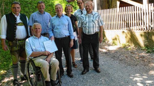 Direkt an der großen Gießenbacher Wassermühle übergab Sebastian Wittmoser (Mitte) den Förderbescheid an Bürgermeister Hajo Gruber (vorne).Foto hoffmann