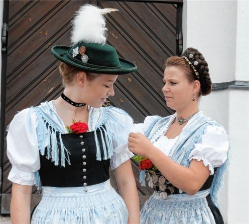 Letzte Kontrolle vor dem Auftritt als Model: Aus Vachendorf kommen Lisa und Vanessa (Foto links). Lisa Hartl richtet ihrer Freundin noch schnell das Tuch, bevor sie vor die Kamera tritt. Auf dem rechten Bild wird letzte Hand an die kunstvolle Gretlfrisur von Elisabeth Hogger aus Teisendorf angelegt. Die stellvertretende Gaujugendleiterin Waltraud Grafetstetter weiß genau, wo die Haarnadeln sitzen müssen.Fotos Kriechbaumer/Erb