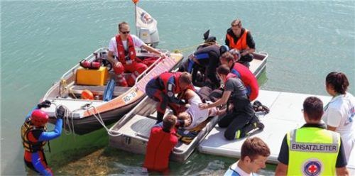 Am Höglinger Weiher löschte die Wasserwacht im Szenario Feuer auf einem Boot und zog es an Land.