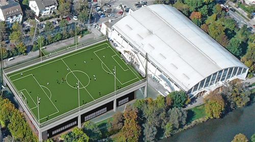 Außergewöhnliche Idee von Stadtrat Robert Multrus, die ebenfalls auf ihre Realisierungsmöglichkeit überprüft wird: eine zweite Eisfläche mit Parkhaus auf dem heutigen Kunstrasenplatz, dieser würde auf dem Dach des Neubaus ersetzt werden. Wie dies aussehen könnte, zeigt unsere Fotomontage.  Ziegler