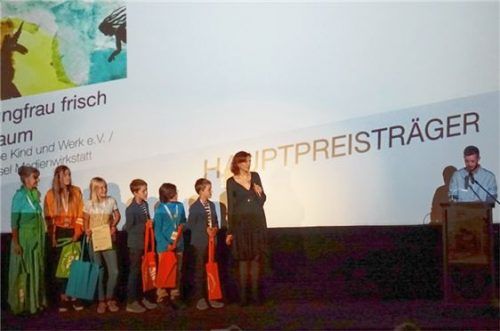 Bei der Siegerehrung (von links): Sonja Wessel, Medienpädagogin, fünf Workshopkinder, die Moderatorin Lena Liberta und Jurymitglied David Johann Lensing. Fotos re