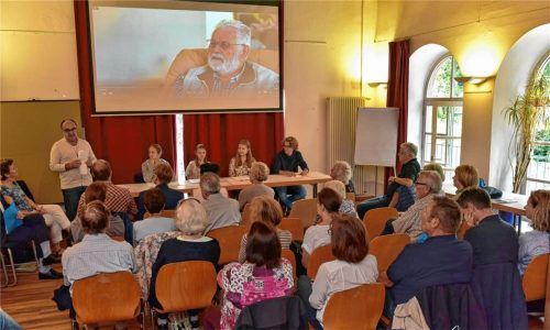 Berührende Lesung von vier Schülern des Ignaz-Günther-Gymnasiums aus dem Tagebuch des ehemaligen Zwangsarbeiters Karel Hobo, heute 90 Jahre (Leinwand-Foto). Karl-Heinz Brauner (links, stehend), Vorsitzender des Historischen Vereins, sprach von einem erstaunlichen Dokument, Journalistin Elvira Biebel-Neu (links, danebensitzend) „entdeckte“ und übersetzte das Tagebuch vom Englischen ins Deutsche. Foto  Neu