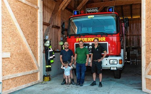 Kommandant Georg Lindner (Mitte), sein Stellvertreter Philipp Heuer (rechts) und Vorsitzender Stephan Bergmann – hier mit dem Nachwuchs – können stolz auf sich und ihre Kameraden sein: Binnen eines Nachmittags wurde in die offene Maschinenhalle von Sebastian Staber ein neues Feuerwehrhaus „eingebaut“. Fotos Thomae