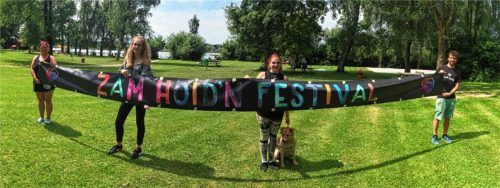 Wo sich ansonsten nur einige Badegäste tummelten, werden am Samstag bis zu 1000 Besucher das „Zamhoid‘n“-Festival feiern. Angelika Narrath (von links), Lena Neumayer, Celina Narrath mit Hund Coco und Juz-Leiter Basti Wörndl stellten sich zwischen Parkplatz-Aufbau und Kuchenbacken zum Pressefoto im Strandbad auf.