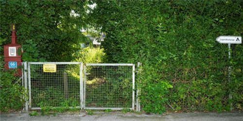 In der Natur sind Gras beziehungsweise andere Pflanzen über die Priener Jugendherberge an der Carl-Braun-Straße 66 gewachsen, in der Kommunalpolitik noch nicht. Unser Bild zeigt den zugewucherten Eingang aufs Gelände. Foto Berger