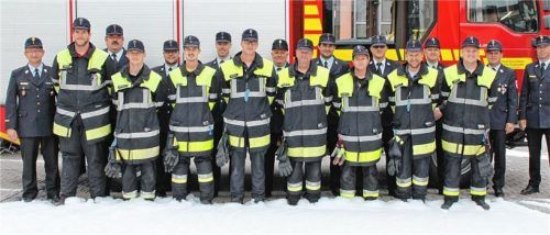 Vor einem Schaumteppich, der zuvor bei der praktischen Prüfung gelegt wurde, präsentieren sich die frischgebackenen Feuerwehr-Maschinisten (in Einsatzkleidung) mit ihren Ausbildern und Prüfern. Links Stadtbrandrat Hans Meyrl, Zweiter von rechts der Westerndorfer Kommandant Peter Höhensteiger, daneben Stadtbrandinspektor Mario Zimmermann.Foto Binder