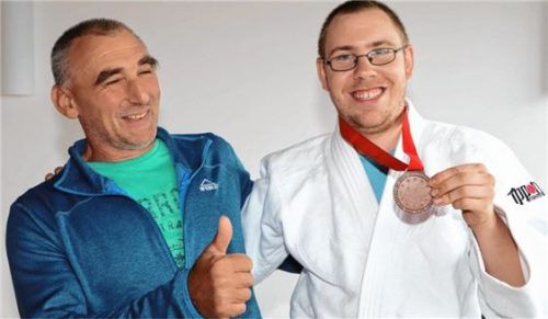 Florian Linsner freut sich mit seinem Trainer über die errungene Bronzemedaille.